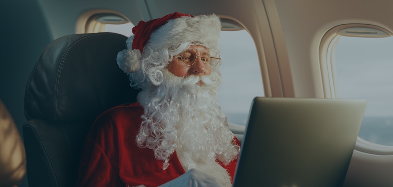 Santa Claus on a laptop on a plane